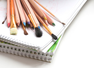 Colored pencils, notepad and paint brushes