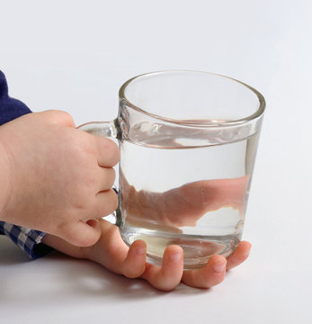 glass of pure water in children hands