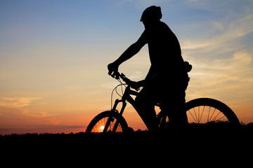 Fototapeta na wymiar Sylwetka Mountain Biker Na Zachód Słońca