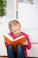 mädchen liest ein buch im wohnzimmer
