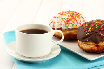Tasty donuts on color plate on light wooden background