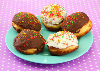 Tasty donuts on color plate on color background