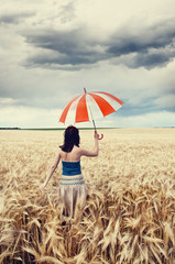 Girl with umbrella at field.