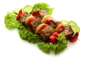 tasty grilled meat and vegetables on skewers, isolated on white