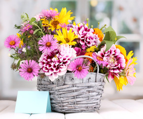 beautiful bouquet of bright flowers in basket on wooden table