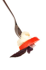 tasty mozzarella with tomatoes on fork isolated on white