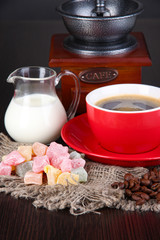 Red cup of coffee with rahat delight, milk and coffee mill