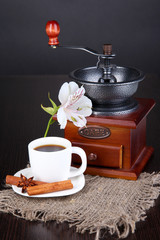 Cup of coffee with coffee mill on wooden table