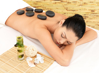 Stone massage for woman at  spa salon.