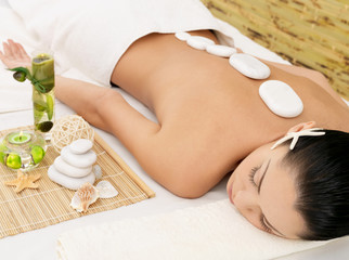 Stone massage for woman at  spa salon.