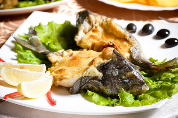 Fried fish garnished on sliced olive and sauce