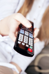 tv remote holded by girl's hand