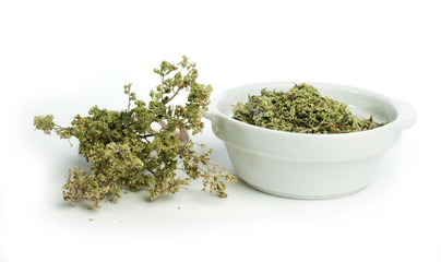 Dried oregano in a bowl and oragano twigs