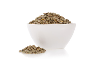 Brown lentils in a bowl isolated on a white background