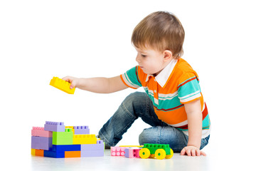 kid boy playing with construction set over white background