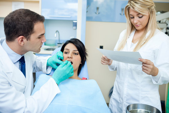 dentist and a nurse  with patient in office