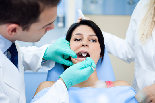 Dentists examining a girl's teeth.