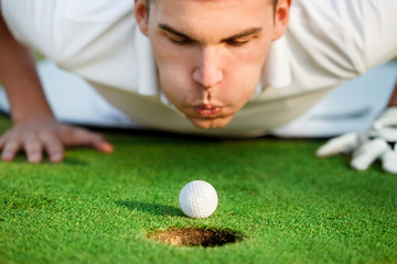 golfer blowing in the ball