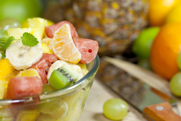 Fresh fruits salad in bowl in kitchen closeup