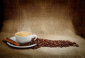 Wall murals Coffee bar warm cup of coffee on brown background
