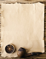 Compass and pipe on the old paper background
