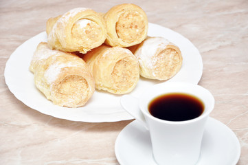 Pastry rolls with cream and coffee