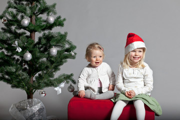 Schwestern neben Weihnachtsbaum