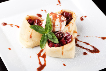 Rolled pancakes with cherry and ice cream