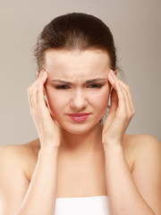 portrait of young beautiful woman having a headache against