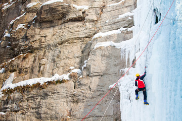Man climbing frozen waterfall