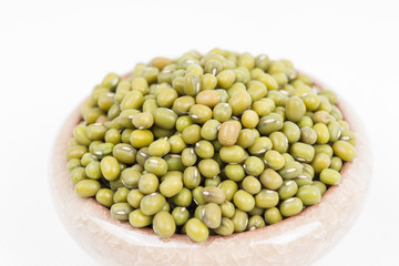 Green mung beans in bowl on white background