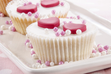 Vanille Cupcake mit rosa und weißen Perlen