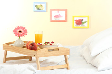 Fototapeta na wymiar wooden tray with light breakfast on bed