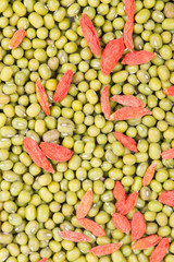 Green mung beans with red chinese wolfberry fruit background