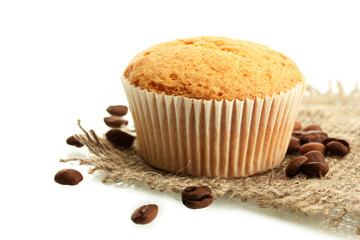 tasty muffin cake on burlap and coffee seeds, isolated on white