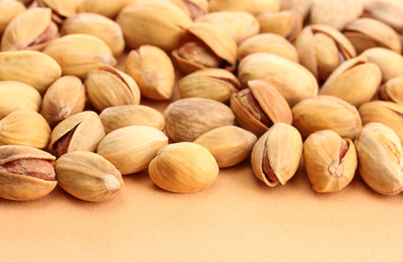 tasty pistachio nuts, on beige background
