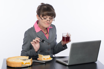 Деловая женщина на рабочем месте ест домашний торт