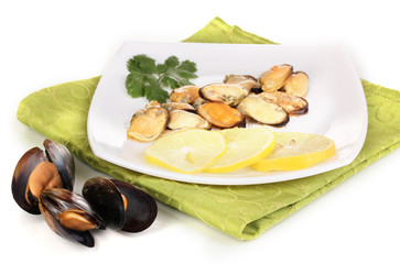Snack of mussels and lemon on plate isolated on white