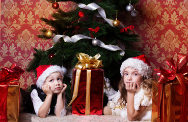 happy children with cristmas presents near the fur-tree