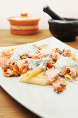 Penne pasta with salmon on table