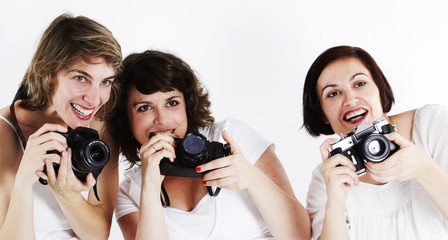 Three women shooting pictures