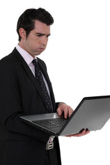 An unhappy businessman with a laptop.