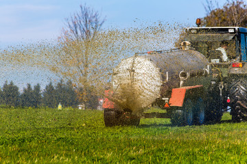 Naklejka premium Traktor düngt mit Gülle ein Feld
