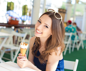 Beautiful young woman relaxing in bar with ice cream