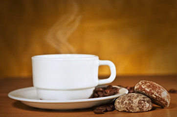 White cup of hot coffee on a saucer and two cakes