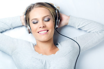 Beautiful blonde woman listening to music at home