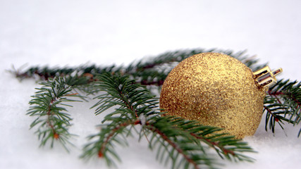 Christbaumkugel im Schneee mit Tannenzweig