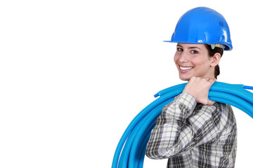 Female plumber carrying pipes