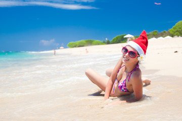 young woman in santa hat laughing at beach, christmas, new year