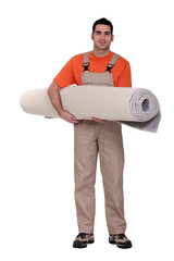 Carpet fitter carrying a roll of carpet